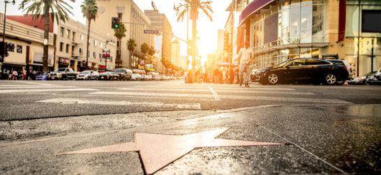 the hollywood walk of fame with cars and tourists