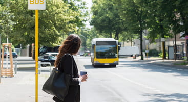 a woman waits for her corporate shuttle to pick her up