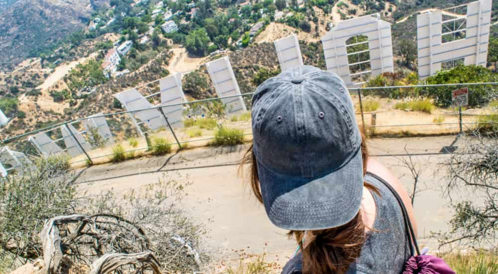 A sightseer looks out across the Los Angeles cityscape from behind the Hollywood sign